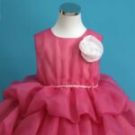 Rochiță Satin Fetițe Roz Intens cu Volane Multiple și Floare Decorativă – Model Elegant pentru Ocazii Speciale